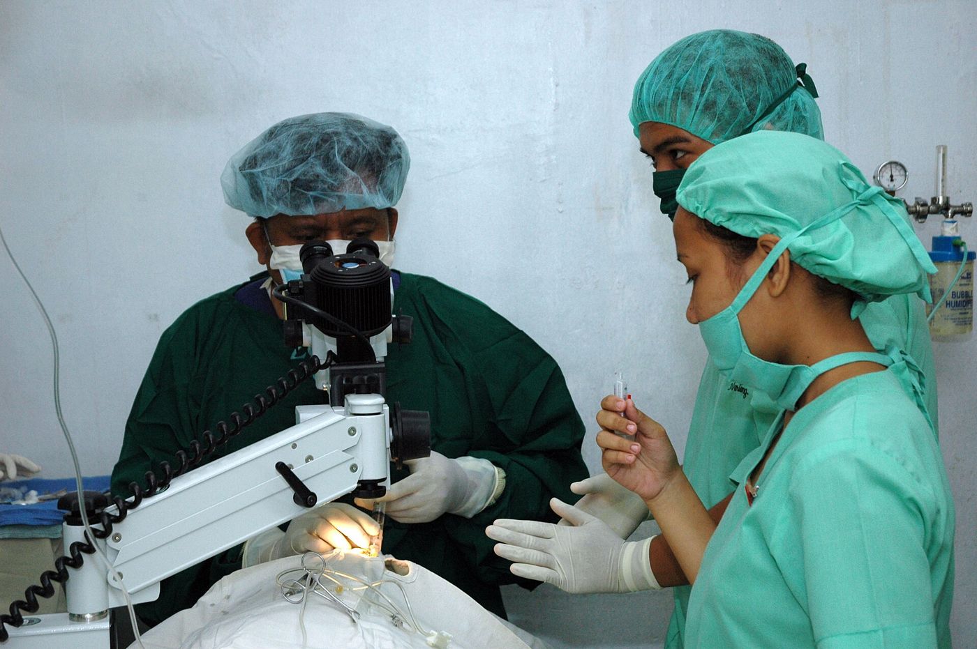 Cirujano oftalmólogo operando con microscopio
